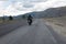 Motorcyclist is traveling by motorcycle on a winding mountain road in summer