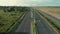 Motorcyclists ride on the freeway. Cinematic drone shot of road with palm trees and transports