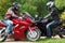 Motorcyclists standing on country road