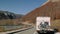 Motorhome RV traveling on empty road in autumn mountains Rbbro. Recreational vehicle caravan