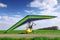 Motorized hang glider over green grass