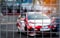 Motorsport car racing on asphalt road. View from the fence mesh netting on blurred car on racetrack background. Super racing car