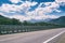 Motorway road in Alps, beautiful day time landscape with blue cloudy sky