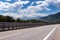 Motorway road in Alps, beautiful day time landscape with blue cloudy sky