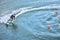 Motosurf Competitor taking corner at speed making a lot of spray. Jet surfing on a water, man riding on jet surfboard. Surfer in