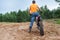 Mototrial rider standing with motorcycle in sand. Extreme sports on motorcross motorbike. Rear view, copyspace