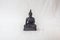 Moulded buddha idol in complete black color in a white backdrop. Macro with extremely shallow depth of field