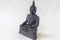 Moulded buddha idol in complete black color in a white backdrop. Macro with extremely shallow depth of field