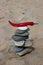 Mound of the balanced river pebbles and hot red pepper on the sandy coast of Olkhon Island