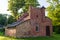 Mound red brick gatekeeper`s house. It looks like a small castle. Lasi, Latvia