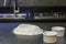 Mound of wheat flour on top of black granite table, preparation of pizza dough