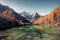 Mount holy Xiannairi reflection on emerald lake in autumn pine forest at Yading