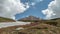 Mount Oshten against a blue sky with cumulus white clouds.