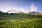 Mount Rainier in the distance behind a meadow in Rainier National Park.