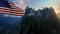 Mount Rushmore with USA Flag blowing in the wind against blue sky