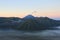 Mount Semeru is erupting the smoke from its crater. And in the front, is mount bromo, which its savana covered by the mist