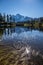 Mount Shuksan and cumulus cloud reflected in rippled Mirror Lake