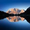 Mount Zugspitze with Alpenglow reflecting in mountain lake