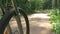 Mountain bicycle wheel spins and rides along ground path