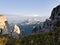 Mountain Big Thach in Caucasus. View from the top of the mountain through the rocks to a green meadow and conifers