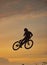 Mountain bike, cyclist and fitness jump at sunset in Colorado countryside nature in workout, exercise or training