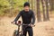 Mountain bike cyclist in forest trail, going with his bike, having rest in open air, enjoying beaitiful nature, sportsman dresses