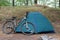 Mountain bike in front of closed tent in the woods in the summer