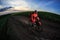 Mountain bikeer rides on the trail against beautiful sunset