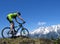 Mountain biker against backdrop of snowy mountains