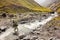 Mountain biker is crossing the river in the highlands of Tusheti region, Georgia