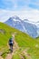 Mountain biker riding in amazing summer Alpine landscape. Snowcapped mountains in the background. Photographed on the trail from