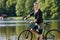 Mountain biking young woman standing by lake