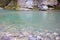 Mountain blue lake among the rocks. Crystal clear turquoise water in a pond in a forest