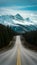 Mountain bound road scenic route winds toward snow capped peaks