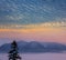 Mountain chain in a snow in a pink mist under the dramatic evening sky