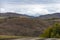 Mountain Charysh Altai Territory, Russia, autumn horizontal landscape with a dirt road taiga, meadows and snow-capped peaks with