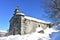 Mountain church Ermita de San Lorenzo after a snowfall with icicles and blue sky. Piornedo Village, Ancares, Lugo, Galicia, Spain.