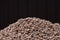 A mountain of clay expanded clay granules on a dark brown background.