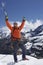 Mountain Climber With Arms Raised On Snowy Peak