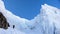 Mountain climber heading up a steep hanging glaicer around seracs in the Alps of Switzerland