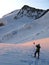 Mountain climber on a rope standing on a large glacier stops to take a photo of the beautiful landscape just after sunrise