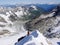 Mountain climber on a summit ridge on his way to a high alpine peak after exiting a tough north face route