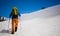 Mountain climber walks on a snowy slope.