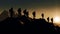 mountain climbers\\\' silhouettes stand as a testament to importance of working together towards a goal