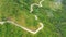 Mountain curve road passing along the slopes of mountains and hills covered with green forest and vegetation