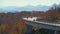 Mountain fall landscape with Linn Cove Viaduct, near Blowing Rock, Blue Ridge Parkway, North Carolina, USA. Driving cars