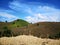 Mountain is filled with corn fields. Which was harvested