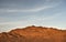 Mountain in gravel desert at sunset