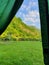 Mountain greenery view with a folding chair from a tent, vertical