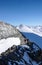 Mountain guide and client on a rocky ridge on their way to a high alpine peak with a great view behind them